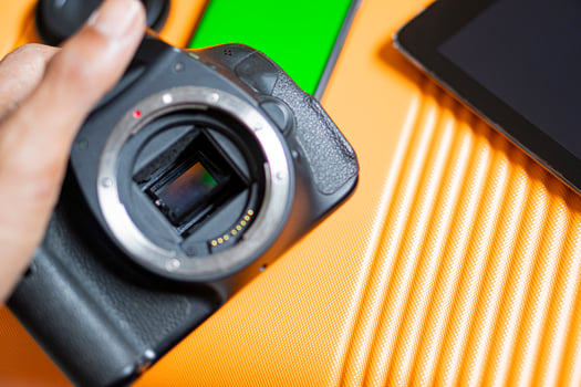 SLR camera and tablet on orange surface photo