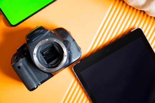 SLR camera and tablet on orange surface photo