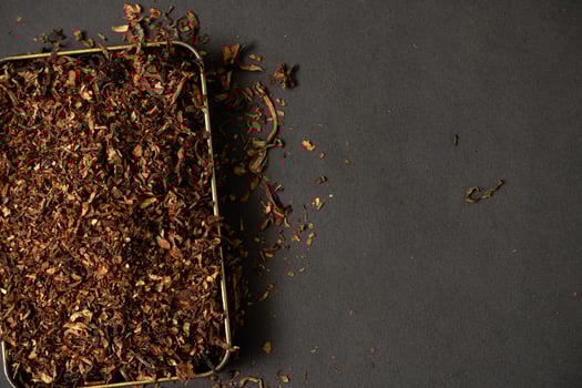 fine tobacco in a gold iron box on a black table photo