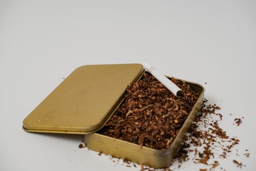 tobacco and some cigarettes around it with a white background photo
