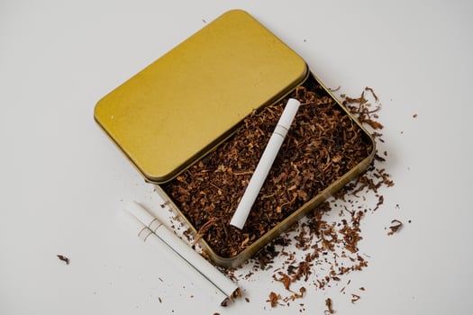 tobacco and some cigarette around it with a white background photo