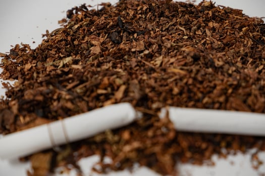 a broken cigarette over fine tobacco photo