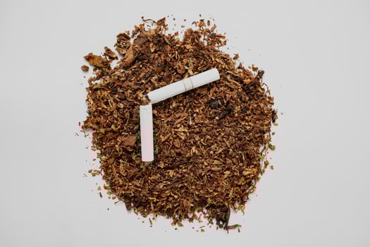 a broken cigarette over fine tobacco photo