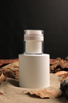 Elegant Cosmetic Jar on White Pedestal with Natural Background photo