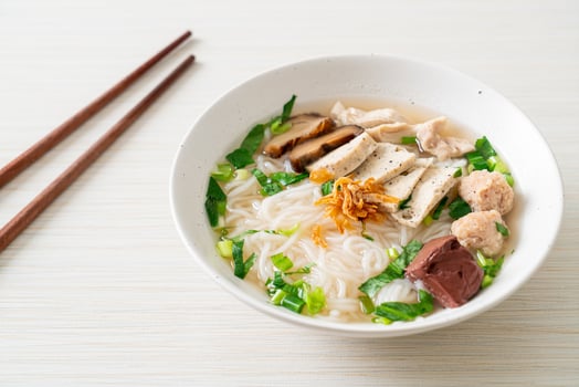 Vietnamese Rice Noodles Soup with Vietnamese Sausage served vegetables and crispy onion photo