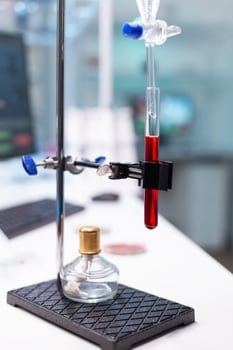 Blood test tube standing in medical equipment ready for biochemistry infection experiment in pharmaceutical biological hospital laboratory. Biology dna sample. Illness infectious research photo