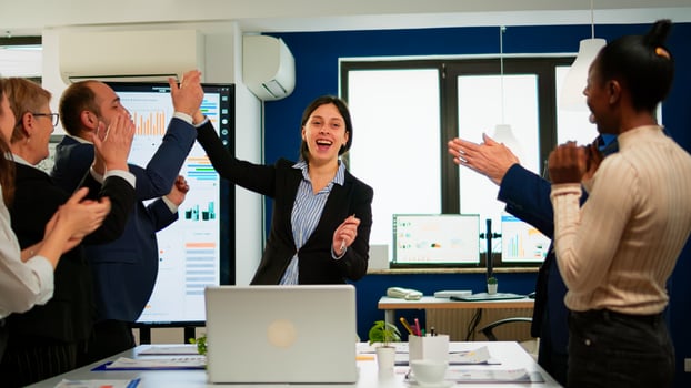 Happy diverse businesspeople designers giving high five during team corporate brainstorm receving good news. Multiethnical partners coworkers celebrate successful teamwork result at company briefing photo