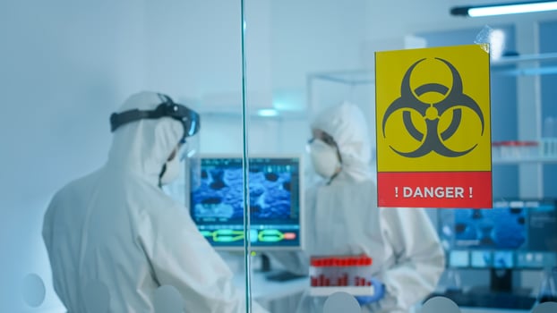 Worried scientists in ppe suit talking behind the glass wall working in danger area of lab. Chemists developing vaccine using tablet examining virus evolution researching for treatment against covid19 photo