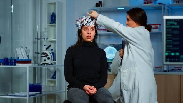 Doctor researcher adjusting EEG headset analyzing patient's evolution after treatment against disease of nervous system. Team of scientists working late night in neurological research laboratory photo