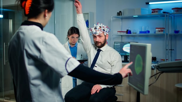 Man patient with high tech headset device participating at neurological experiment in technologically advanced laboratory testing physical reactions and nervous system photo