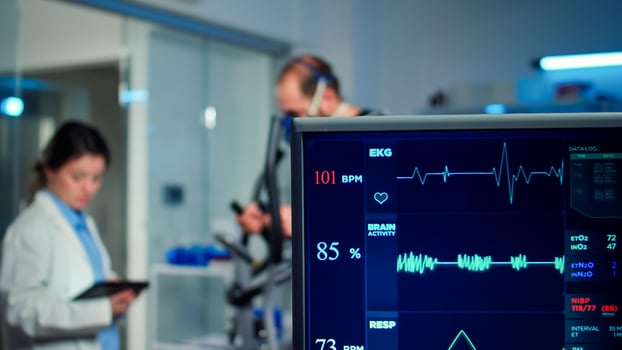 Specialist health supervisor increasing level of exercises measuring muscle endurance of athlete. Medical researcher measuring vo2 of performance sports running with mask on cross trainer in sport lab photo
