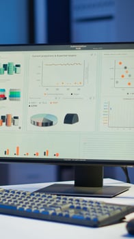 Financial company with nobody in it, place of work startup, workplace indoors concept. Interior of empty start up business office with modern design during night with graphics running on the desktop. photo