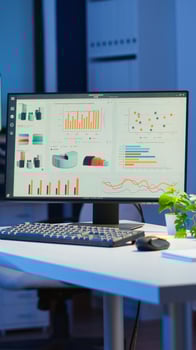 Empty start up business office with modern design during night with graphics running on the desktop. Financial company with nobody in it, place of work startup, workplace indoors concept photo
