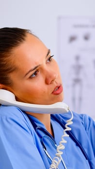 Close up of assistant answering phone checking the result of patient x-ray and diagnosing him. Healthcare physician in medicine uniform, receptionist doctor nurse helping with telephone concultation photo