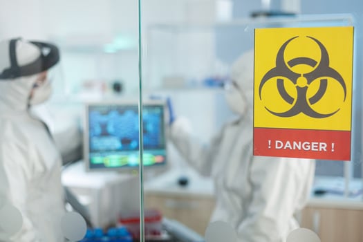 Biologist scientists wearing medical protection suit working in microbiological hospital laboratory developing vaccine against covid19 using high biotechnology. Scientific team during medicine experiment photo