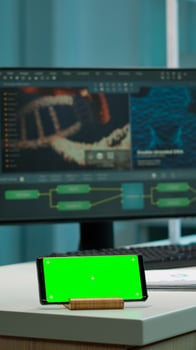 Scientist standing at monitor in background analysing virus evolution while phone with mock-up green screen working in front. Woman lab researcher examining vaccine developent bringing blood samples photo