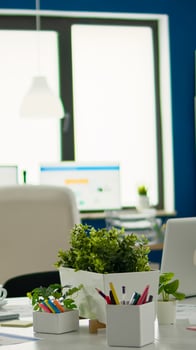 Brainstorm area in business center with nobody in it, shot of empty room with modern furniture, white shelves and blue wall. Modern business meeting zone interior with conference table and white chair photo