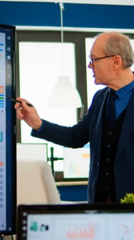 Experienced project leader analysing financial presentation during business conference in brainstorming room using digital devices. Multiethnical team working in professional startup company during meeting photo