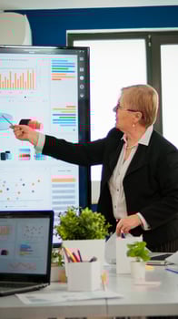 Experienced senior woman CEO CTO of start up company sharing financial reports project strategy briefing diverse group of investors. Multiethnical businesspeople working in professional startup financial company during conference photo