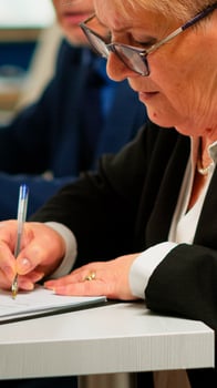 Busiess partners discussing new project for company evolution, senior manager woman checking tasks on clipboard and signing new contract. Executive director meeting shareholders in start up office photo