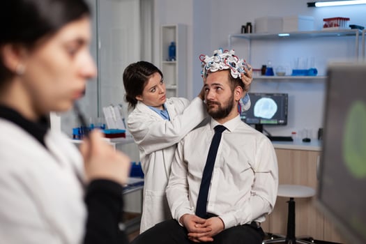 Specialist researcher woman putting eeg headset on man patient analyzing brain evolution monitoring nervous system activity in neurology laboratory. Doctor in neuroscience doing medical tomography photo