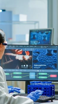 Team of scientists worried about virus evolution discussing in equipped laboratory pointing at computer. Stuff examining vaccine development using high tech researching treatment against covid19 virus photo