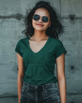 A young woman wearing a green V-neck t-shirt stands in front of a concrete wall photo
