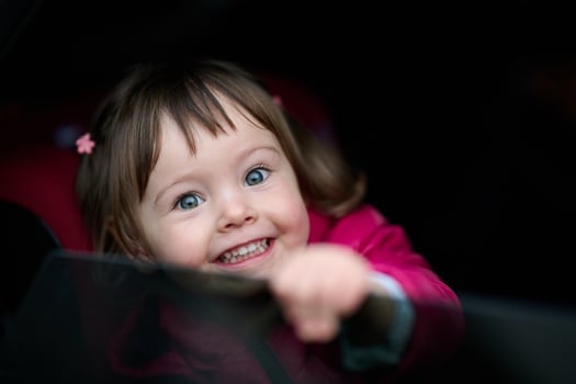 A young girl sits comfortably in a modern car seat, secured and ready for a family adventure on the road. photo