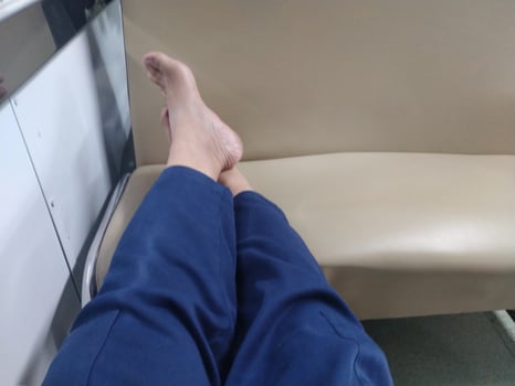 human legs resting on the train seat. barefoot on the seat during the train journey. relieve fatigue photo