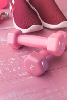 Yoga mat and dumbbells on floor, close up photo