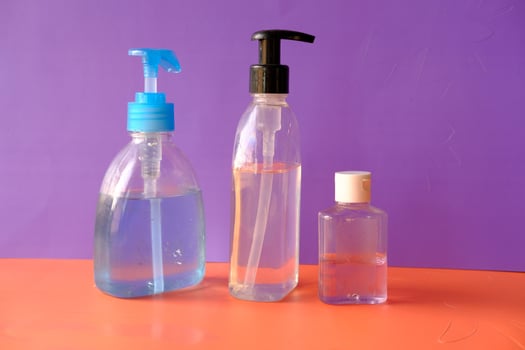 hand sanitizer and liquid soap on color background photo