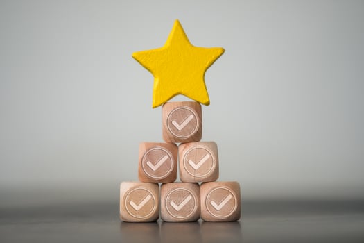 Star shape put on top of wood block with check mark, wood stack like a pyramid. Concept of excellence photo