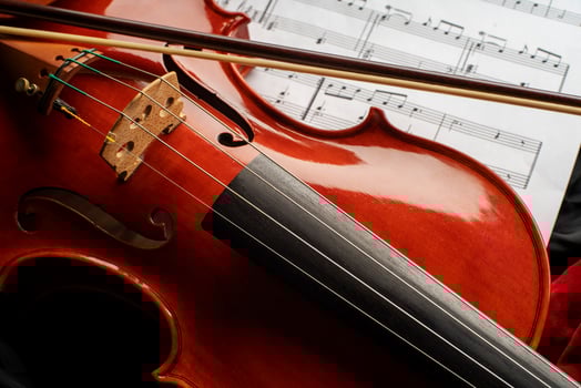 Violin body and a bow with musical score photo
