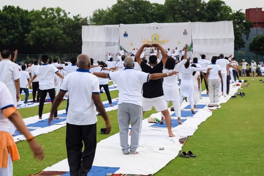 Group Yoga exercise session for people of different age groups at cricket stadium in Delhi on International Yoga Day, Big group of adults attending yoga session photo