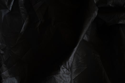 Black crumpled paper with shadow for background. wrinkled surface, design, wallpape photo