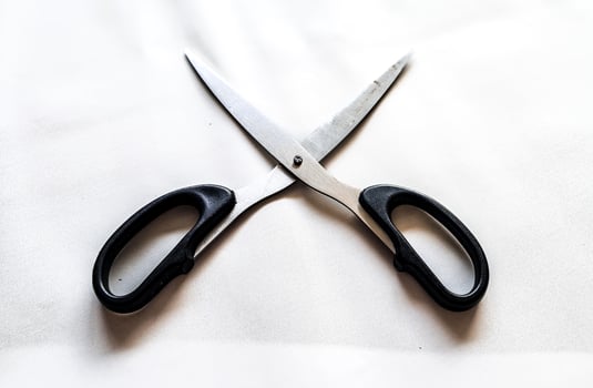 A pair of scissors with a black handle and a white background photo