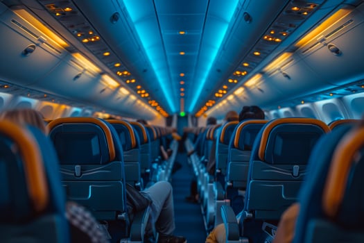 A plane is filled with passengers, some of whom are sleeping photo