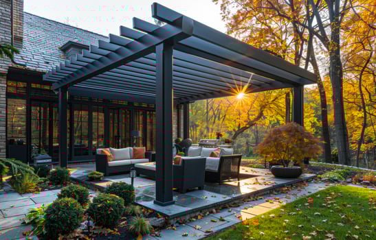 A patio with a black pergola and a sunlit area photo