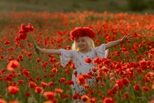 A young girl is standing in a field of red poppies, wearing a red headband photo