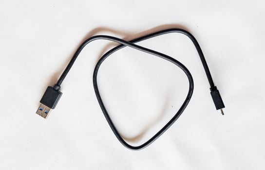 A black USB cable and a white background photo