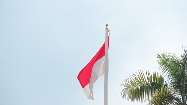The Indonesian flag flutters in the wind against a blue sky photo