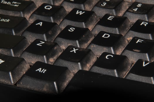 Close-Up View of a Dirty Computer Keyboard with Crumbs and Dust photo