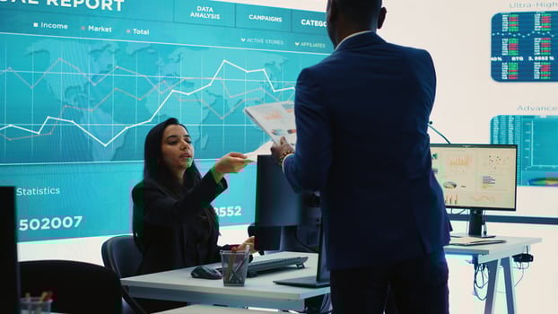 Corporate analysts looking into project details and timetables, team leader providing flyers with budget and operations plan to achieve business goals in a competitive environment. Camera A. photo