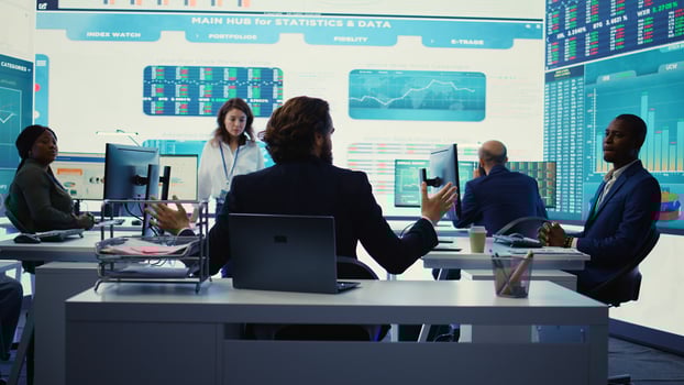 Chairman of the advisory board transmits potential company expansion plans, supervisor and the staff look into data visualizations on a big screen. Teamwork to boost affordable earnings. Camera B. photo