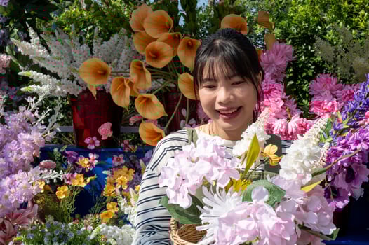 An attractive Asian female florist with a beautiful bouquet in front of her flower shop. photo