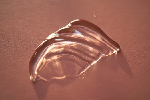 Beautiful volumetric drop of cosmetic product on a pink background. photo