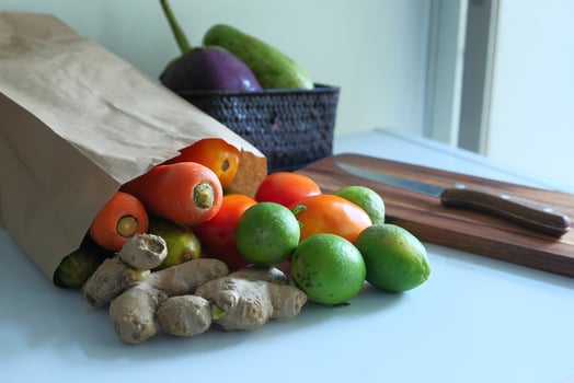 fresh vegetable in a shopping bag and knife on table photo