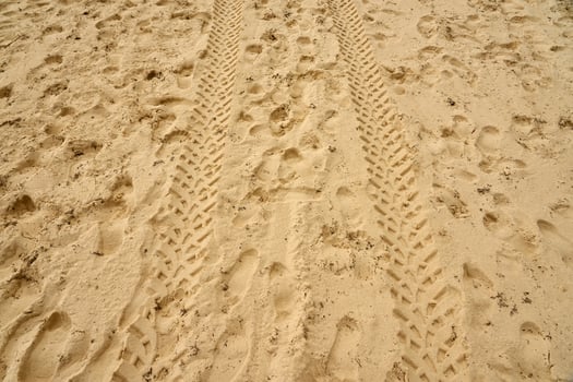 Traces of people and vehicles in the sand. photo