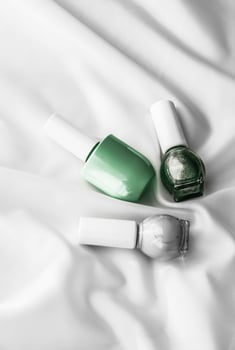 Nail polish bottles on silk background, french manicure products and nailpolish make-up cosmetics for luxury beauty brand and holiday flatlay art design photo
