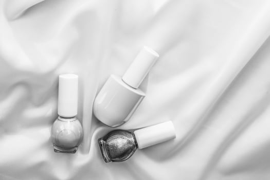 Nail polish bottles on silk background, french manicure products and nailpolish make-up cosmetics for luxury beauty brand and holiday flatlay art design photo